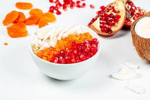 Oatmeal porridge with fruit and coconut on a white background