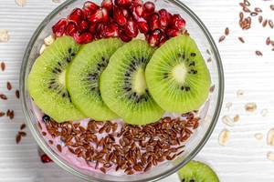 Oatmeal with flax seeds, kiwi slices and pomegranate. The concept of a healthy Breakfast. Top view (Flip 2019)