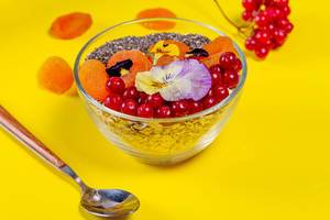 Oatmeal with fruit, Chia seeds and flowers on a yellow background (Flip 2019)