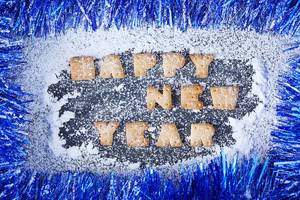 Obene Aufnahme von Buchstabenkeksen schreiben “Happy new year”