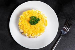 Obene Aufnahme von gesundem Salat aus Eiern, Kartoffeln, Schinken, Mayonnaise und Petersilien