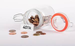 Offenes Glasgefäß mit kleinen Cent-Münzen und dem Etikett "401k"