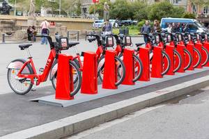 Öffentlicher Fahrradverleih "Bicing" bietet knallrote Räder in Fahrradständer abgestellt, zum Mieten am Katalonienplatz in Barcelona, Spanien