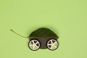 Ökologisch fahren und fortbewegen – grünes Blatt mit zwei Rädern vor hellgrünem Hintergrund