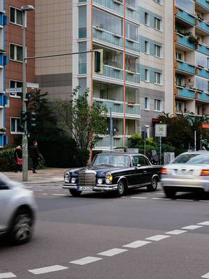 Old legacy Mercedes-Benz car at the intersection in modern Berlin.jpg