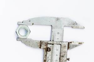 Old wrench with iron nut on white background