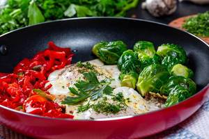 Omelet with Brussels sprouts and bell pepper in a frying pan