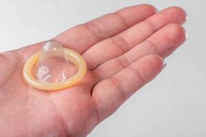 On the hand of a man condom on a white background