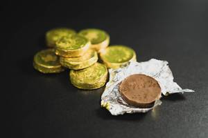 Open chocolate coin on a black surface