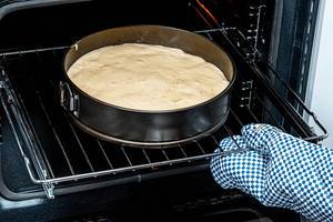 Open electric oven with baking tray and cake dough