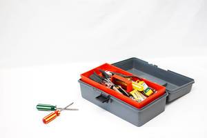 Open Toolbox with Screwdrivers in front of it on white Background
