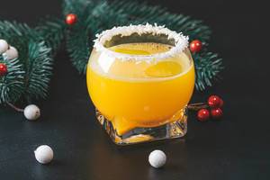 Orange cocktail on a new year background with Christmas tree branches (Flip 2019)