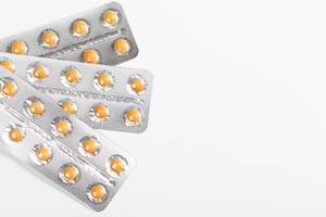 Orange pills in blisters on a white background with free space