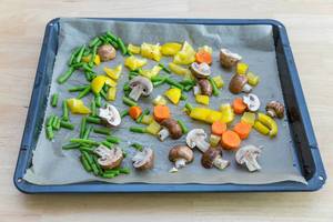 Oven-roasted vegetables on baking paper prior to roasting