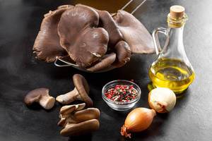 Oyster mushrooms with spices, onion and olive oil on a black background (Flip 2019)