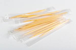 Packed wooden toothpicks on white background