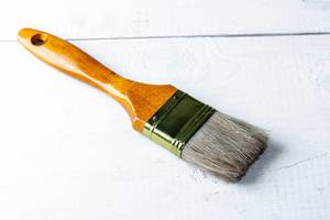 Paint brush on white wooden background