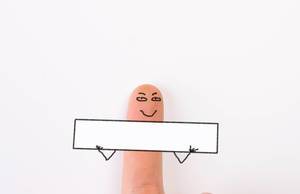Painted happy finger is holding empty board