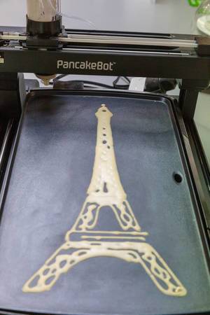 PancakeBot spritzt Crêpe in Form von Eiffelturm auf integrierte Backplatte