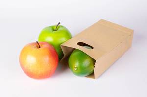 Paper bag with fruits on white background