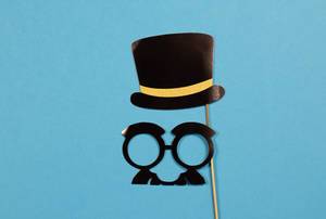 Paper hat and glasses on blue background