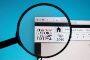 PC-Bildschirm mit geöffneter Internetseite des Oxford Literary Festivals und Lupe über Logo
