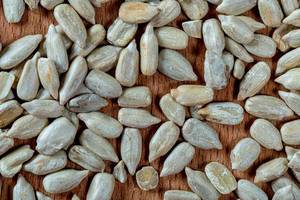 Peeled Sunflower seeds on wooden background. Top view