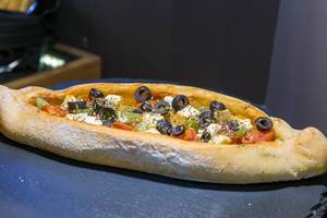 Peinirli: Pizzaschiffchen auf griechische Art mit Tomaten, Oliven, Käse und Kräutern