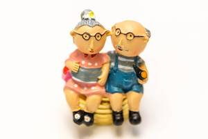 Pension Plan - retired couple on a stack of coins