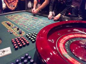 People playing roulette at a gambling table in a casino