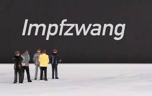People standing in front of Impfzwang text
