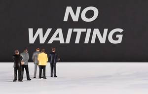 People standing in front of No Waiting text