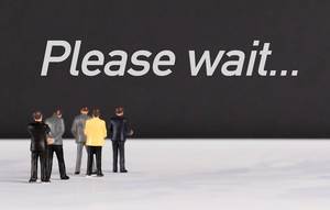 People standing in front of Please Wait text