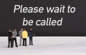 People standing in front of Please wait to be called text