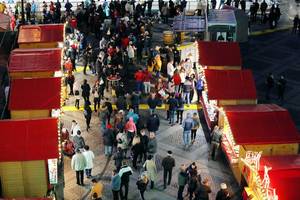 People walking between Christmas huts, view from above