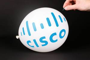 Person bringt einen Luftballoon mit Cisco Systems Logo mit einer Stecknadel zum platzen mit schwarzem Hintergrund