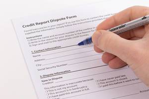 Person füllt ein Streitbeilegungs-Dokument für den Kreditbericht mit einem Kugelschreiber aus