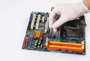 Person mit Gummihandschuhen repariert eine Hauptplatine eines Computers mit einem Schraubenzieher mit weißem Hintergrund