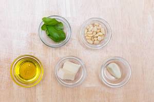Pesto-Zutaten: Olivenöl, Parmesan, Knoblauch, Pinienkerne und Basilikum