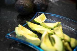 Pice of lemon in a plate with avocados