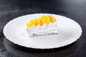 Piece of cake with white cream and citrus marmalade