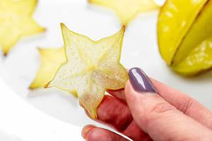 Piece of fruit carambola in a woman
