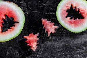 Pieces of watermelon in the shape of a Christmas tree on a black background