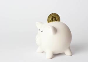 Piggybank in white with a bitcoin in it
