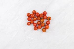 Pile of Cherry Tomatoes on the grey marble table with copy space