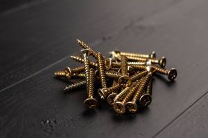 Pile of yellow Screws on the black background