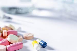 Pillen und Tabletten in verschiedenen Farben und Formen vor weißem Hintergrund