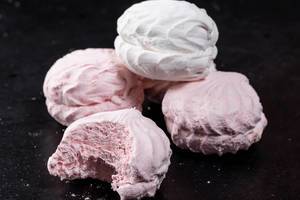 Pink and white marshmallow on black background