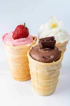 Pink, brown and white ice cream in cups