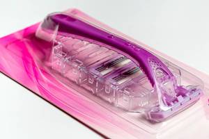 Pink female razor with blades on a white background